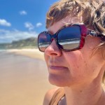 Katherine standing on a beach with sunglasses on, taken on Salmon Beach, Whadjuk Noongar Country